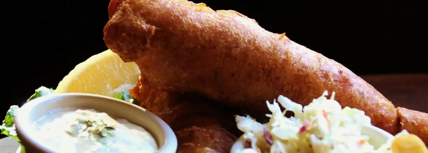 Harp lager battered fish and chips with fries and coleslaw